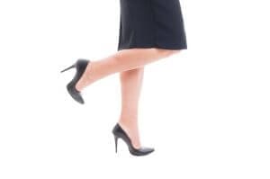 Business woman legs with high heels black leather shoes and skirt isolated on white background